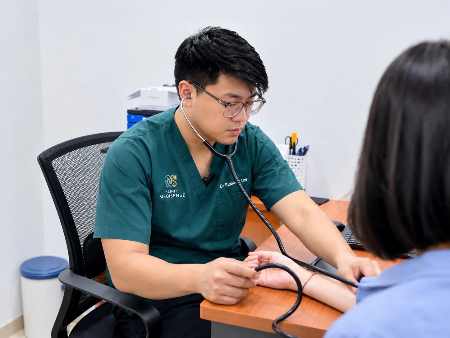 Dr. Mohamad Ridhwan examining a patient at Klinik Medisense